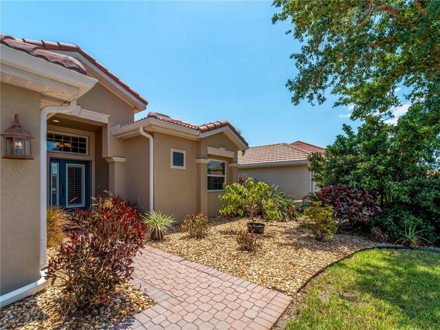 11982 Granite Woods Loop, Venice, FL 34292 - property entrance featuring a tile roof and stucco siding