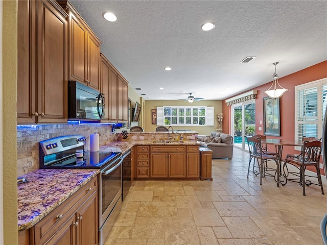11982 Granite Woods Loop, Venice, FL 34292 - kitchen with stainless steel electric range, black microwave, a sink, a peninsula, and tasteful backsplash