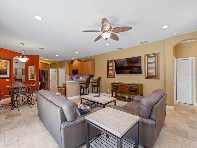 11982 Granite Woods Loop, Venice, FL 34292 - living area featuring arched walkways, stone tile floors, a ceiling fan, recessed lighting, and baseboards