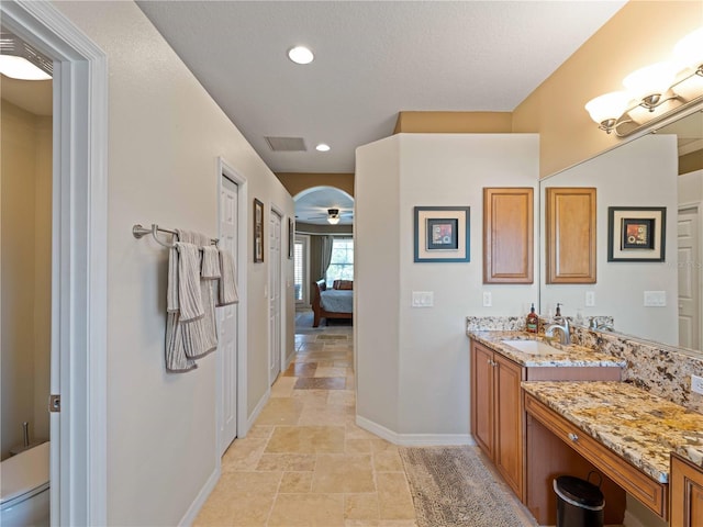 11982 Granite Woods Loop, Venice, FL 34292 - ensuite bathroom with baseboards, vanity, stone finish flooring, and recessed lighting