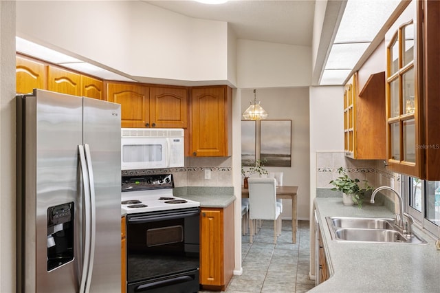 3301 Santa Barbara Dr, Punta Gorda, FL 33983 - kitchen with stainless steel refrigerator with ice dispenser, white microwave, range with electric cooktop, a sink, and brown cabinets