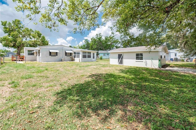 back of house featuring a lawn and stucco siding