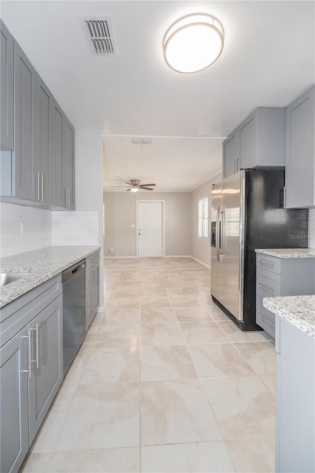 kitchen featuring dishwashing machine, gray cabinetry, a ceiling fan, and decorative backsplash