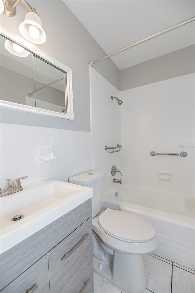 full bathroom with tile walls, shower / tub combination, toilet, vanity, and marble look tiles