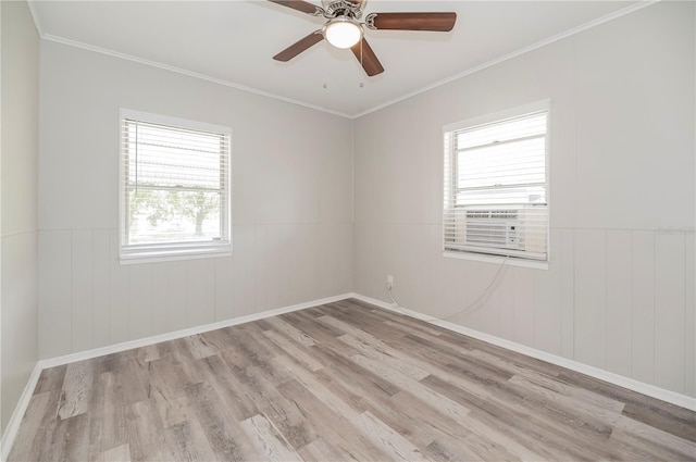 unfurnished room with wood finished floors, ornamental molding, a wainscoted wall, ceiling fan, and baseboards