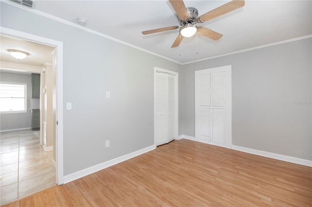 unfurnished bedroom with ornamental molding, baseboards, light wood finished floors, and ceiling fan