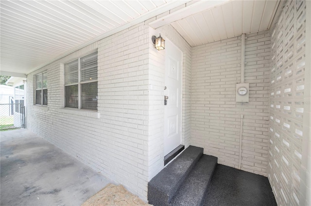 doorway to property with brick siding and covered porch