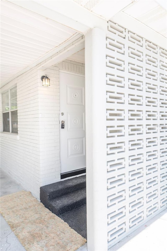 entrance to property featuring brick siding