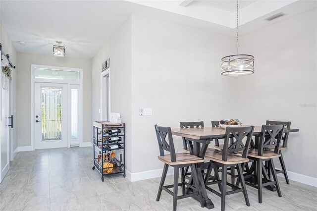 dining space featuring baseboards, a chandelier, and light marble finish flooring
