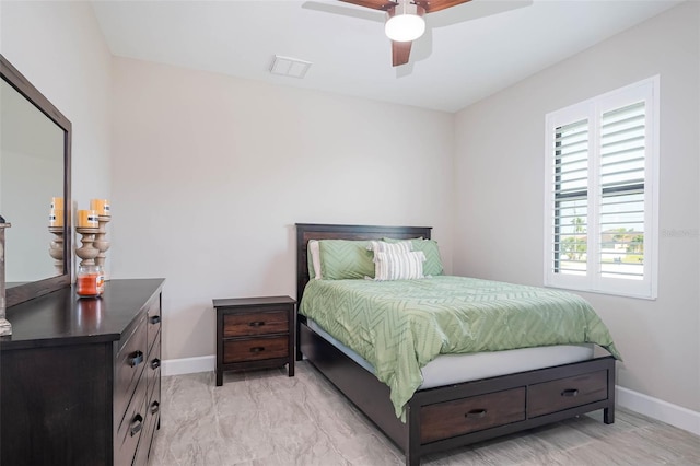 bedroom featuring baseboards, light marble finish floors, and a ceiling fan