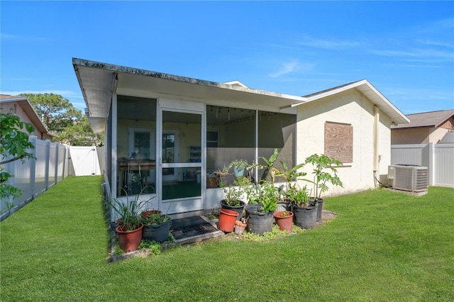 back of house featuring a sunroom, central AC, and stucco siding