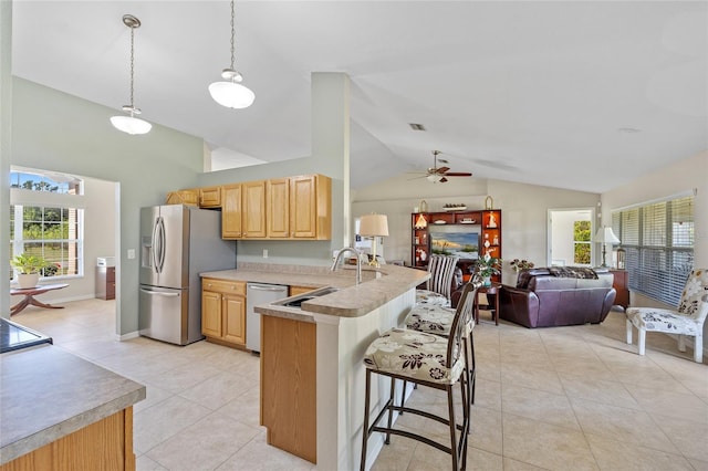 27038 San Jorge Dr, Punta Gorda, FL 33983 - kitchen with stainless steel appliances, light brown cabinetry, a ceiling fan, a kitchen bar, and light tile patterned floors