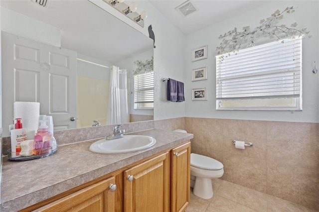 27038 San Jorge Dr, Punta Gorda, FL 33983 - full bathroom with tile patterned floors, toilet, a shower with curtain, vanity, and tile walls