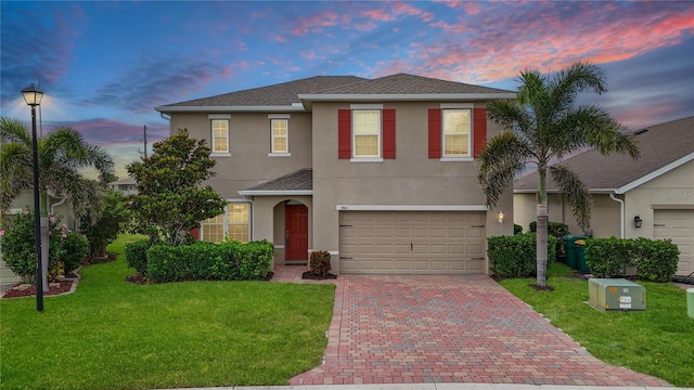 3941 River Bank Way, Punta Gorda, FL 33980 - traditional-style home featuring decorative driveway, stucco siding, a front yard, a garage, and roof with shingles