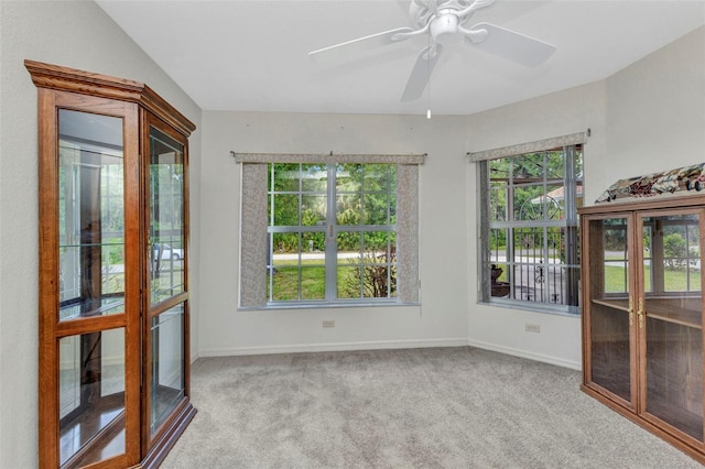 carpeted spare room with baseboards and ceiling fan