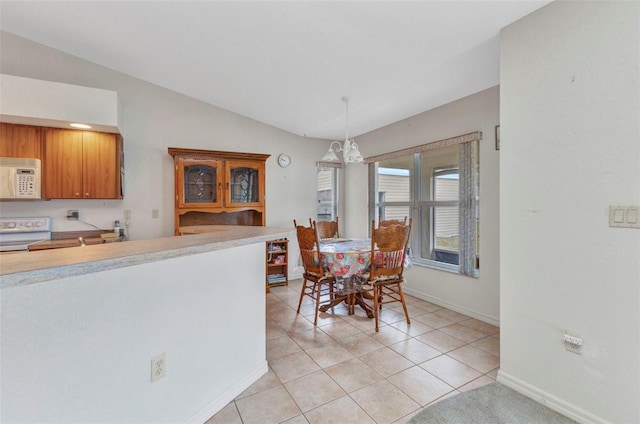 dining area featuring lofted ceiling, baseboards, light tile patterned flooring, and a chandelier