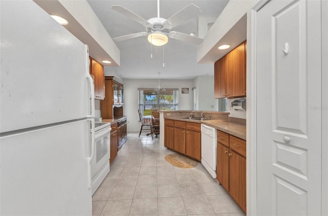 kitchen featuring white appliances, a sink, brown cabinetry, light tile patterned floors, and recessed lighting