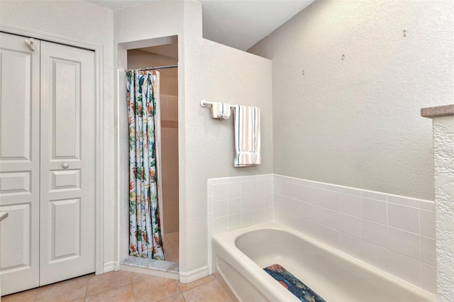 full bath featuring tile patterned flooring, a garden tub, and tiled shower