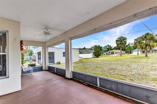 unfurnished sunroom with ceiling fan