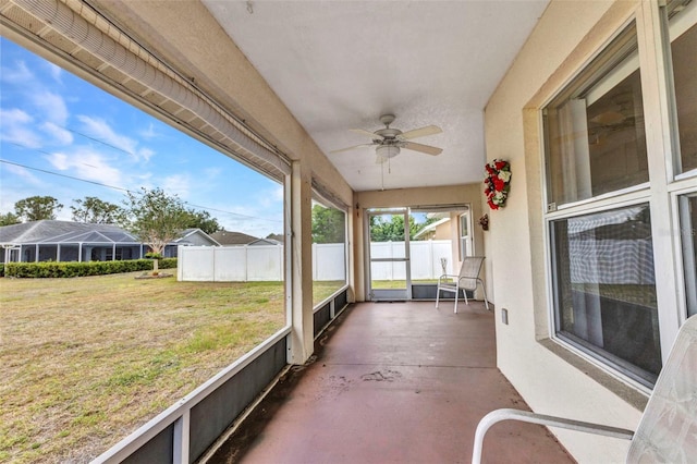 unfurnished sunroom featuring a ceiling fan