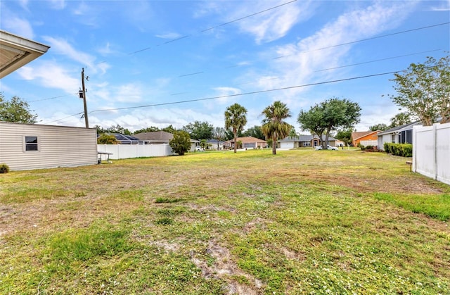 view of yard featuring fence and a residential view