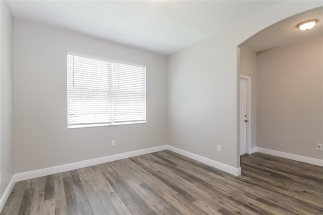 20067 Oakflower Ave, Tampa, FL 33647 - empty room with arched walkways, wood finished floors, and baseboards