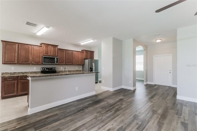 20067 Oakflower Ave, Tampa, FL 33647 - kitchen with appliances with stainless steel finishes, arched walkways, a sink, and wood finished floors