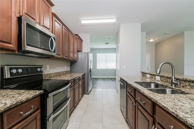 20067 Oakflower Ave, Tampa, FL 33647 - kitchen with appliances with stainless steel finishes, a sink, light stone counters, and light tile patterned flooring