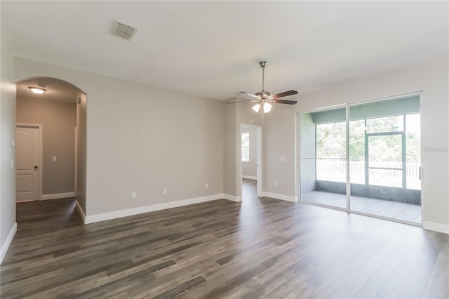 20067 Oakflower Ave, Tampa, FL 33647 - empty room featuring arched walkways, a ceiling fan, healthy amount of natural light, and dark wood-type flooring