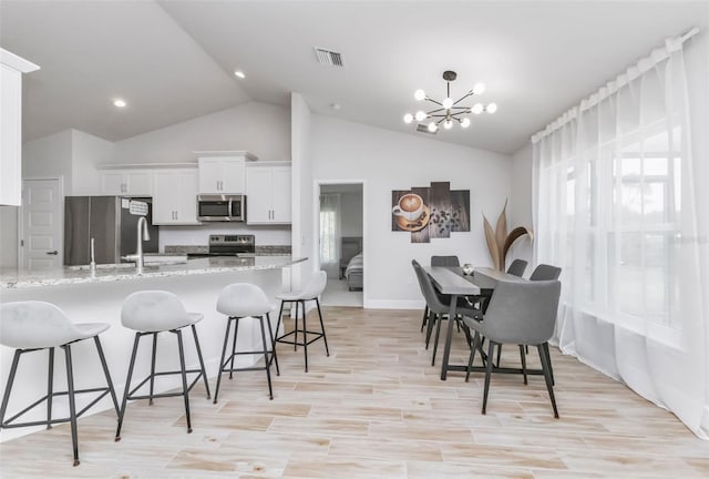 7664 Meroni Blvd, North Port, FL 34291 - dining area with a chandelier, baseboards, light wood-type flooring, high vaulted ceiling, and recessed lighting