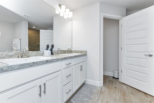 7664 Meroni Blvd, North Port, FL 34291 - full bath featuring baseboards, double vanity, wood finished floors, and recessed lighting