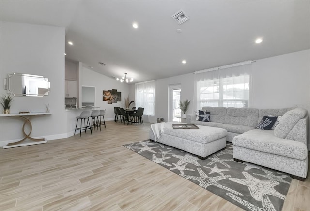 7664 Meroni Blvd, North Port, FL 34291 - living room with lofted ceiling, a chandelier, recessed lighting, wood finished floors, and baseboards