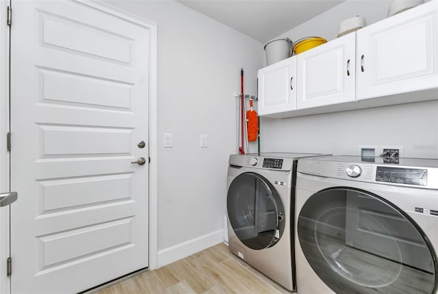 7664 Meroni Blvd, North Port, FL 34291 - washroom featuring cabinet space, washer and dryer, baseboards, and light wood-style flooring