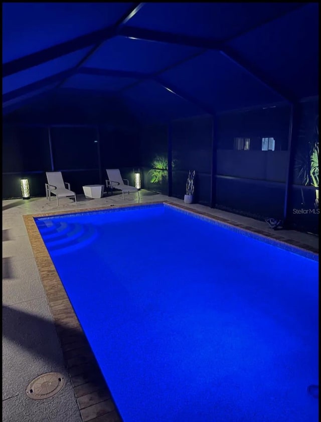 7664 Meroni Blvd, North Port, FL 34291 - pool at twilight featuring an outdoor pool, a patio area, and glass enclosure