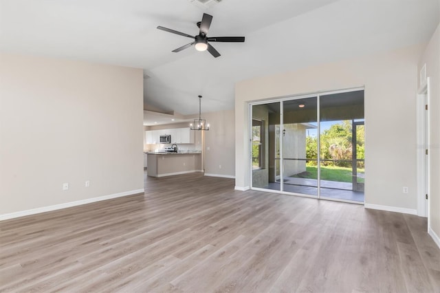 2381 Sheila Ln, North Port, FL 34286 - unfurnished living room with lofted ceiling, light wood-type flooring, ceiling fan, baseboards, and a chandelier