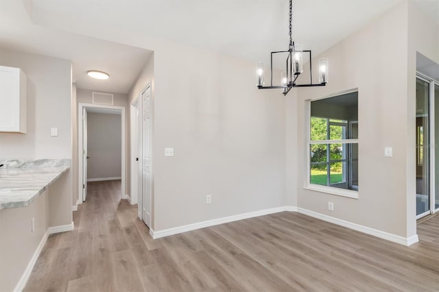 2381 Sheila Ln, North Port, FL 34286 - unfurnished dining area with light wood finished floors, a chandelier, and baseboards