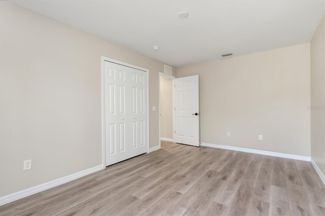 2381 Sheila Ln, North Port, FL 34286 - unfurnished bedroom with light wood finished floors, baseboards, and a closet