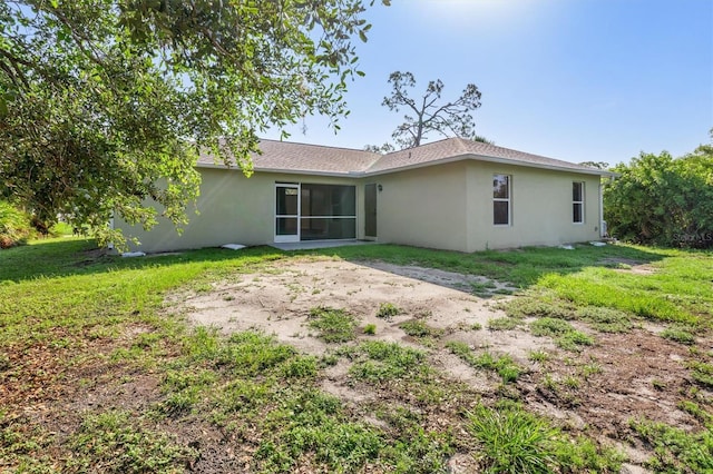 2381 Sheila Ln, North Port, FL 34286 - rear view of house featuring stucco siding and a yard