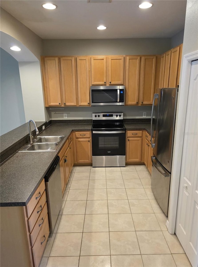 1271 Jonah Dr, North Port, FL 34289 - kitchen with appliances with stainless steel finishes, light tile patterned flooring, dark countertops, recessed lighting, and a peninsula