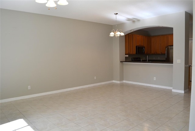 1271 Jonah Dr, North Port, FL 34289 - kitchen featuring stainless steel appliances, a chandelier, dark countertops, arched walkways, and decorative light fixtures
