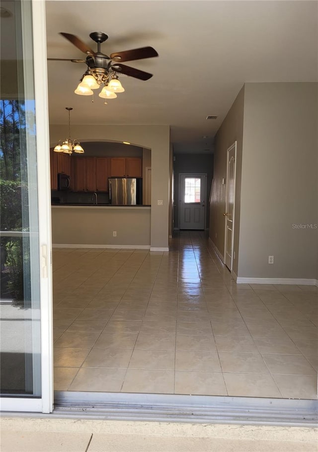 1271 Jonah Dr, North Port, FL 34289 - unfurnished living room featuring light tile patterned flooring, a chandelier, and ceiling fan