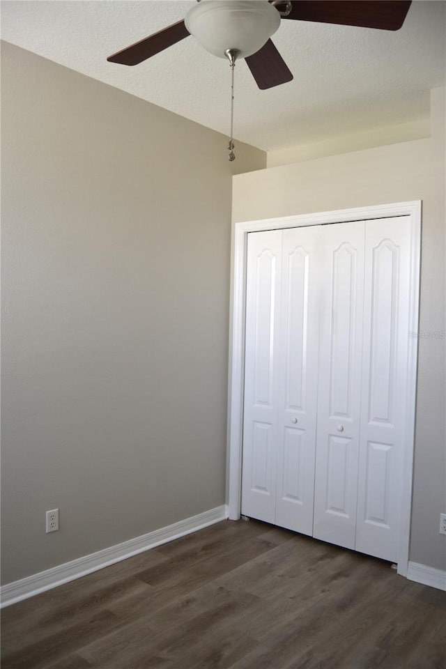 1271 Jonah Dr, North Port, FL 34289 - unfurnished bedroom with dark wood-style flooring, a closet, and a ceiling fan