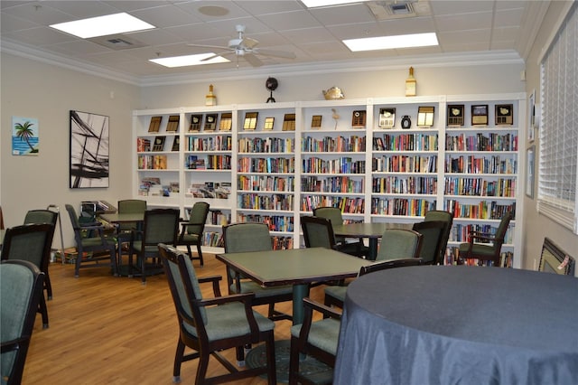 1271 Jonah Dr, North Port, FL 34289 - office space with wall of books, wood finished floors, crown molding, and ceiling fan