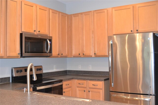 1271 Jonah Dr, North Port, FL 34289 - kitchen featuring appliances with stainless steel finishes, dark countertops, and light brown cabinets