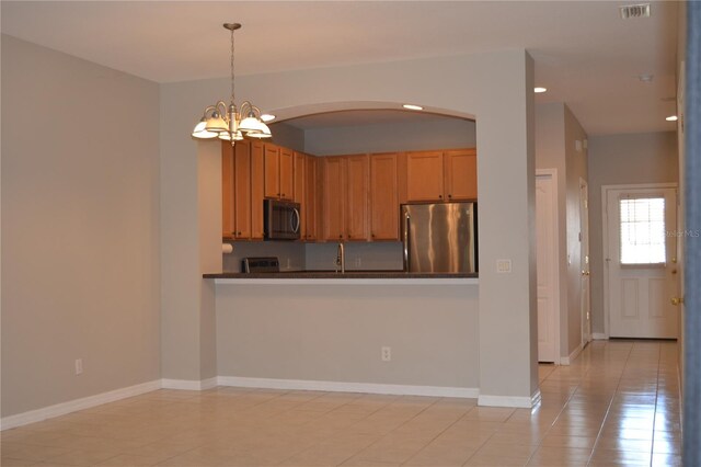 1271 Jonah Dr, North Port, FL 34289 - kitchen featuring appliances with stainless steel finishes, dark countertops, arched walkways, a chandelier, and hanging light fixtures