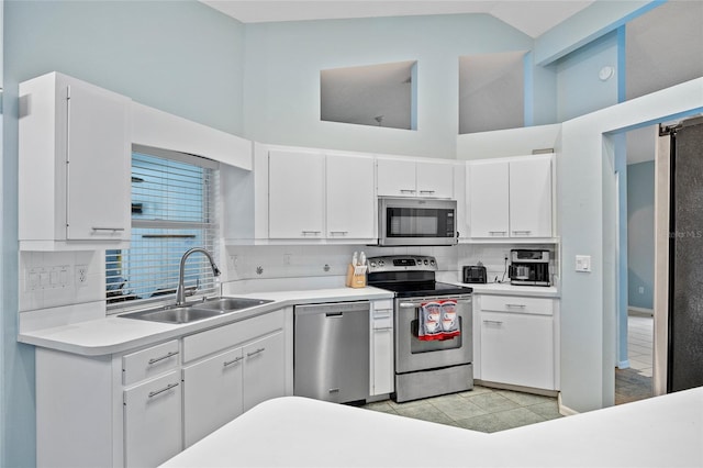 1 Sportsman Way, Rotonda West, FL 33947 - kitchen with stainless steel appliances, a sink, high vaulted ceiling, tasteful backsplash, and white cabinets