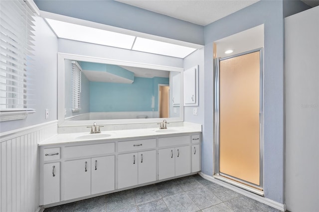 1 Sportsman Way, Rotonda West, FL 33947 - bathroom featuring double vanity, a stall shower, and a wainscoted wall