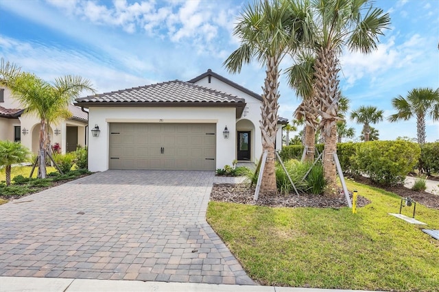 281 Potenza Loop, Nokomis, FL 34275 - mediterranean / spanish home featuring stucco siding, decorative driveway, an attached garage, a front lawn, and a tile roof
