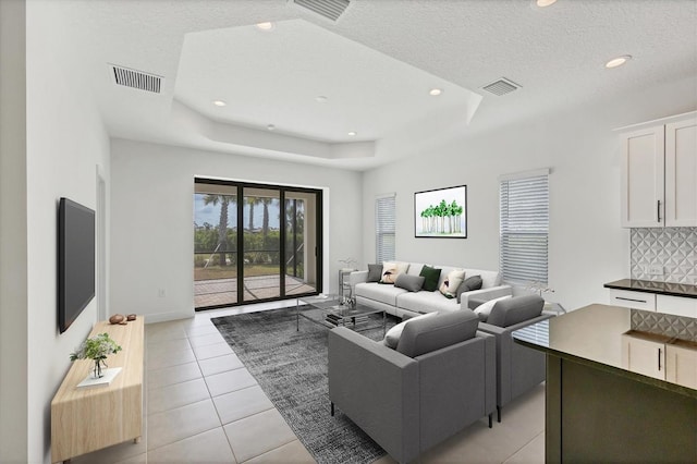 281 Potenza Loop, Nokomis, FL 34275 - living room with a tray ceiling, a textured ceiling, recessed lighting, light tile patterned floors, and baseboards