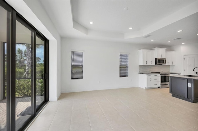 281 Potenza Loop, Nokomis, FL 34275 - kitchen with appliances with stainless steel finishes, a sink, decorative backsplash, white cabinetry, and baseboards